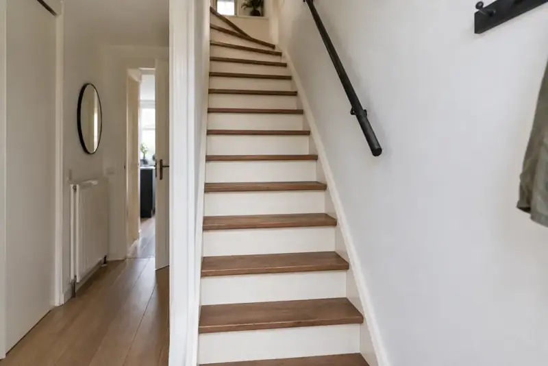 Na renovatie: exact dezelfde steile trap met notenhouten treden en lichte stootborden