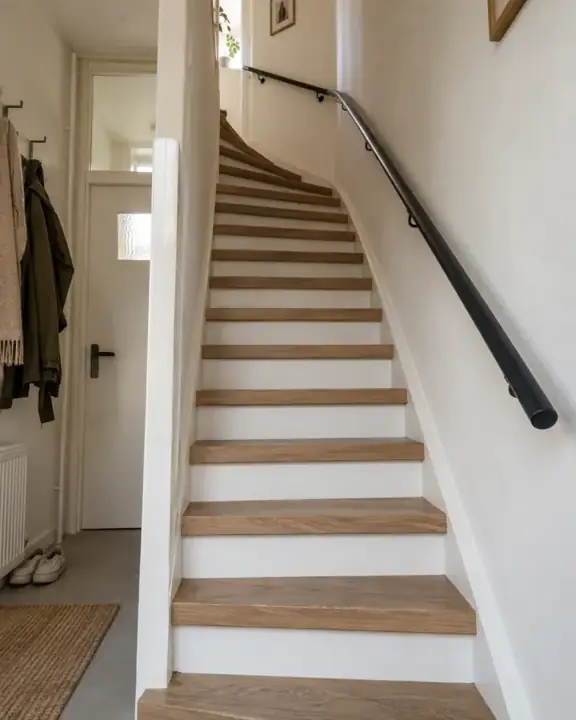Een compacte kwartslagtrap in een jaren 70 woning, met eiken treden en witte stootborden