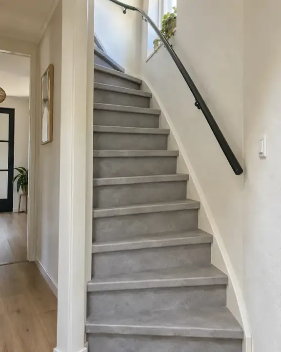 Lichtgrijze PVC trap in steenlook in de hal van een jaren 90 rijtjeswoning