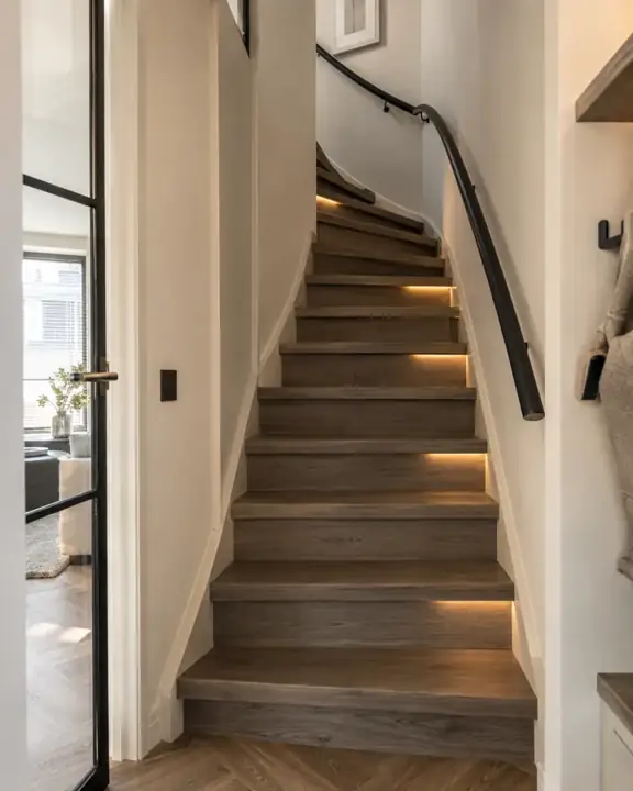 Kwartslagtrap in gerookte eikenlook PVC met subtiele LED verlichting in een jaren 90 woning